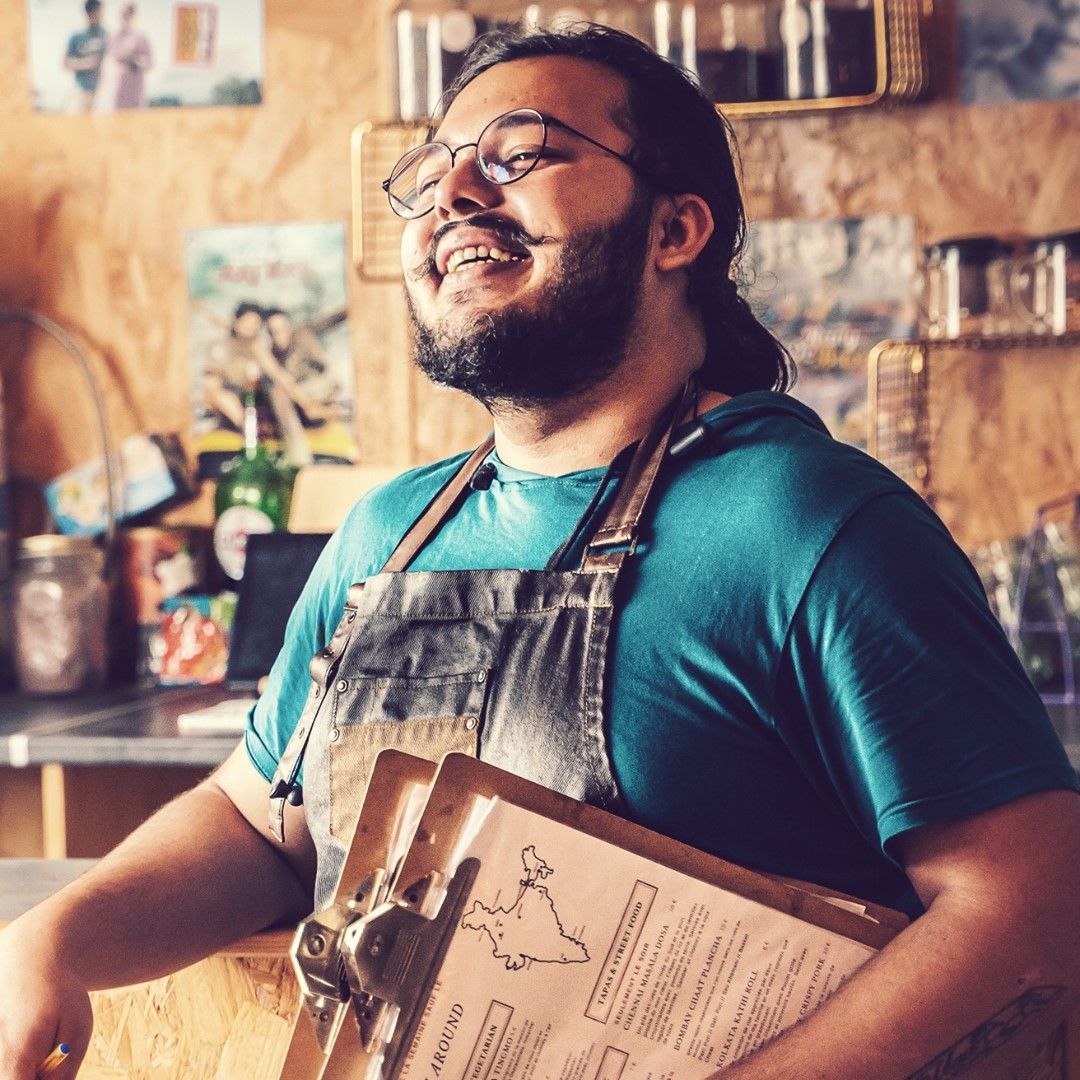 Le Chef Deb, riant, menus en main au bistro