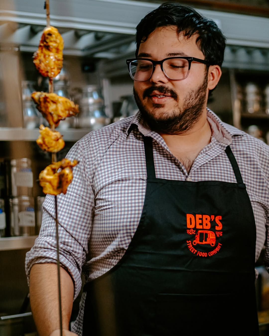 Chef Deb lifting a skewer from the tandoor
