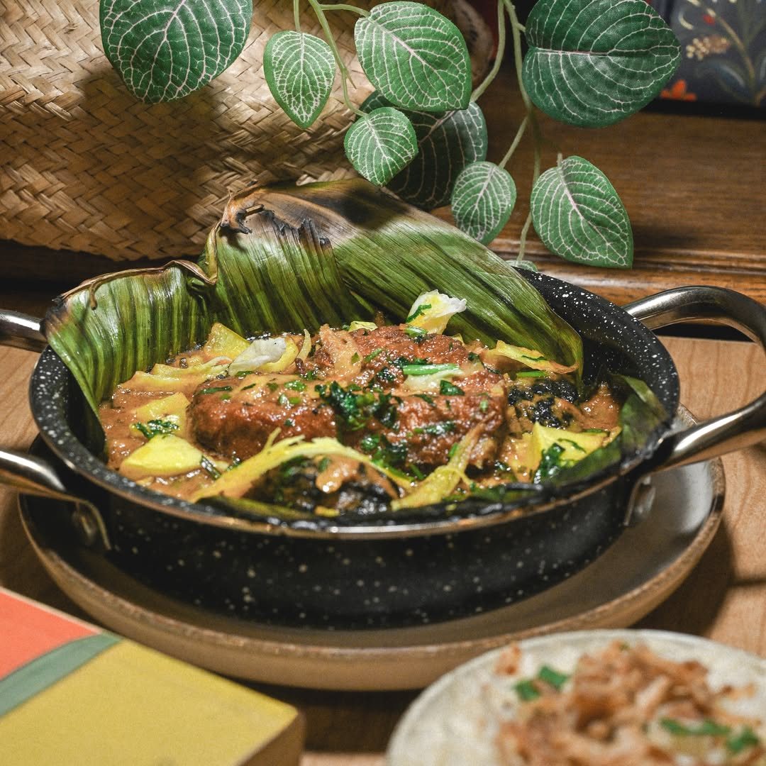 Mangalore fish curry in a pan set on banana leaf
