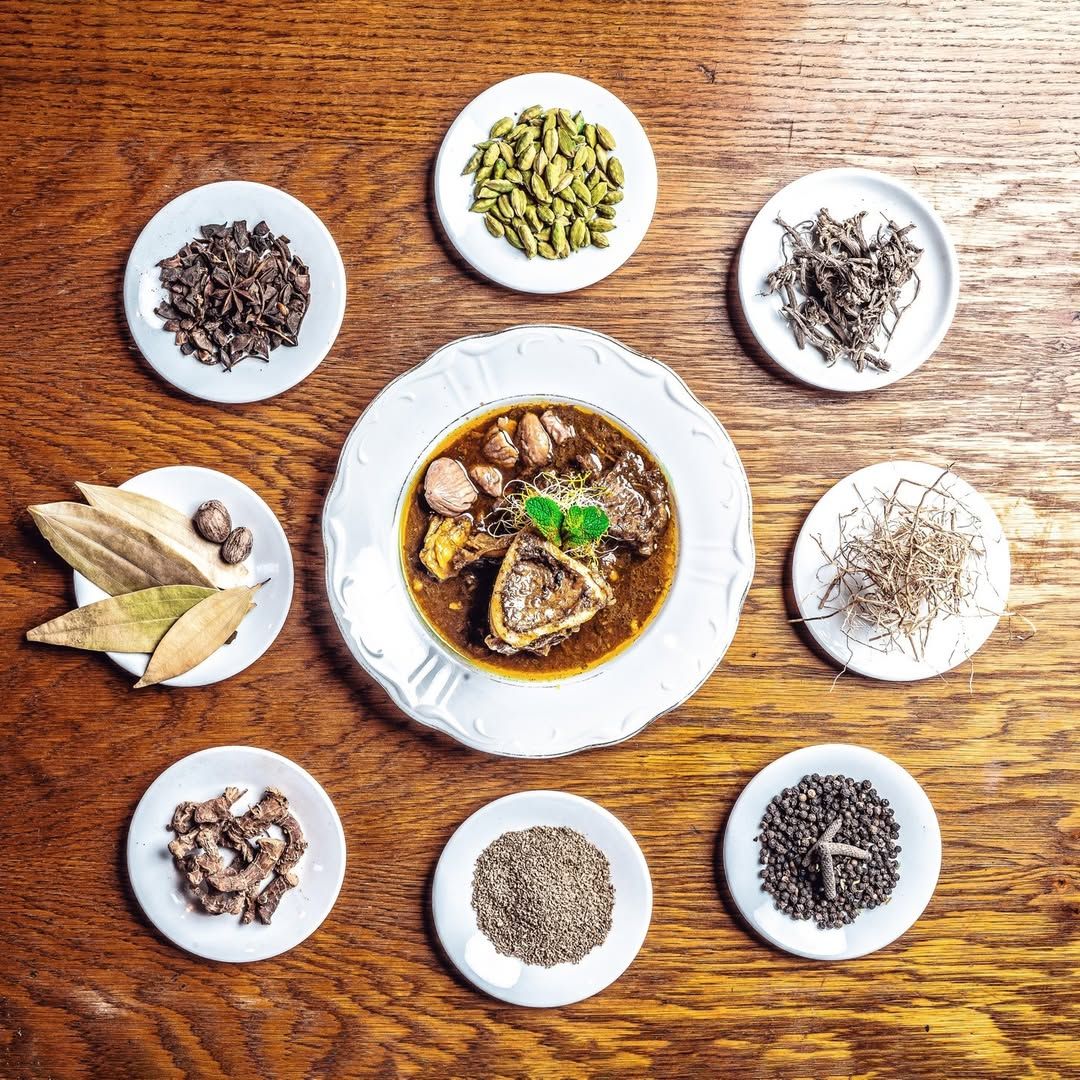 Nihari surrounded by the whole spices used in its house blend
