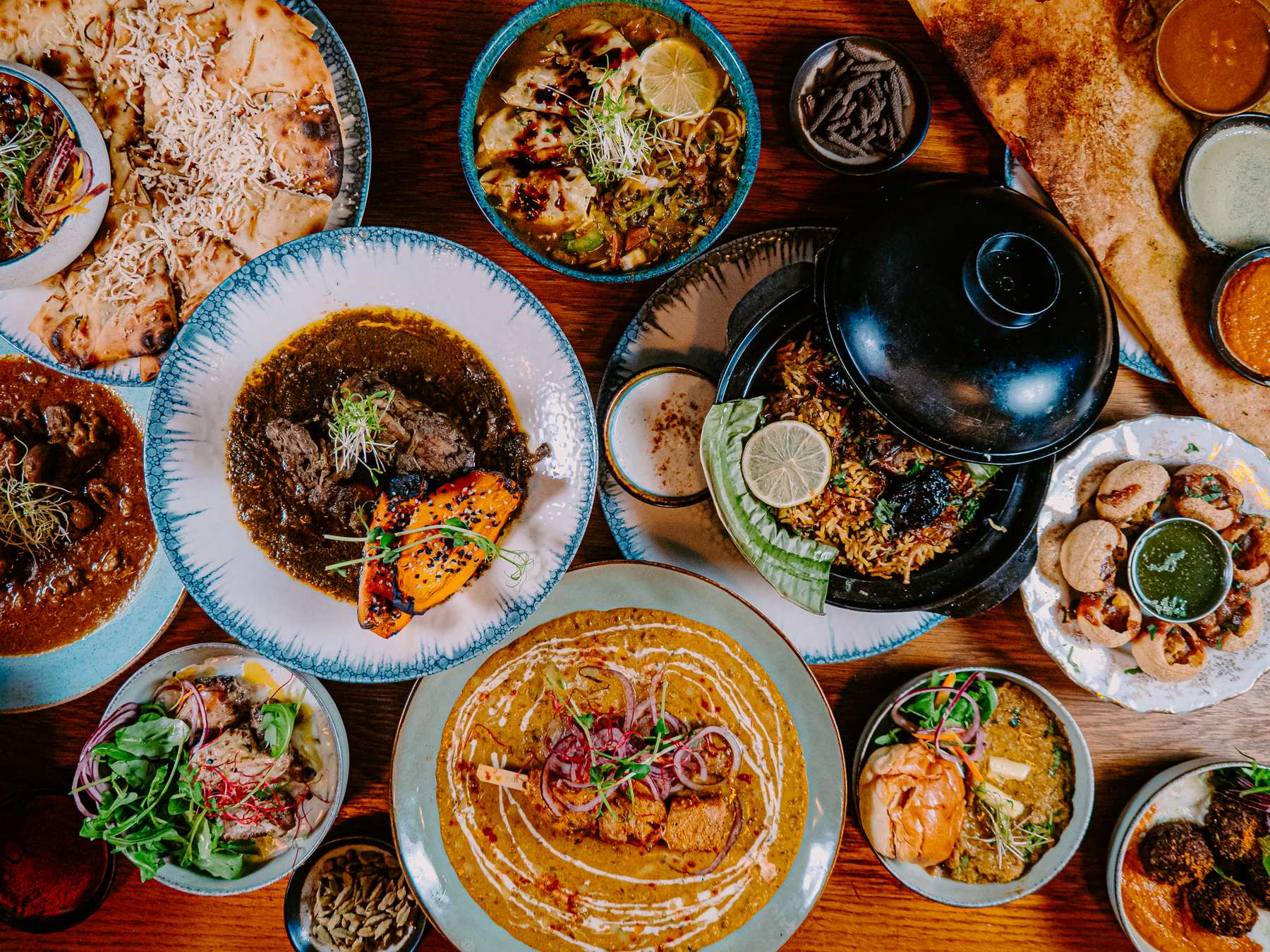 An overhead spread of regional Indian dishes on a table at Deb's Bistro
