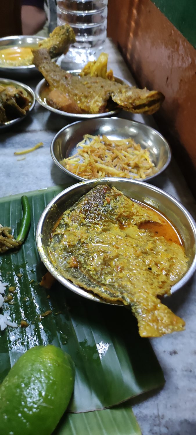 A fish thali in steel bowls at a local eatery