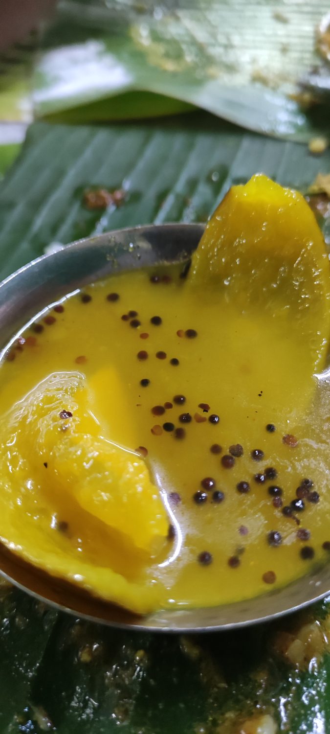 A yellow mango dal with tempered spices in a steel bowl